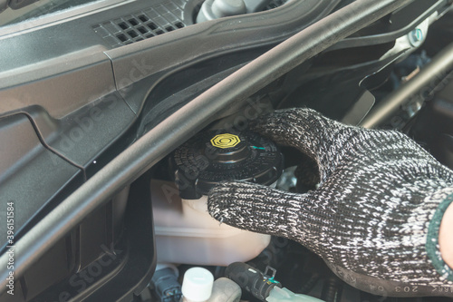 Close up of Auto mechanic checking brake fluid, Car maintenance service.