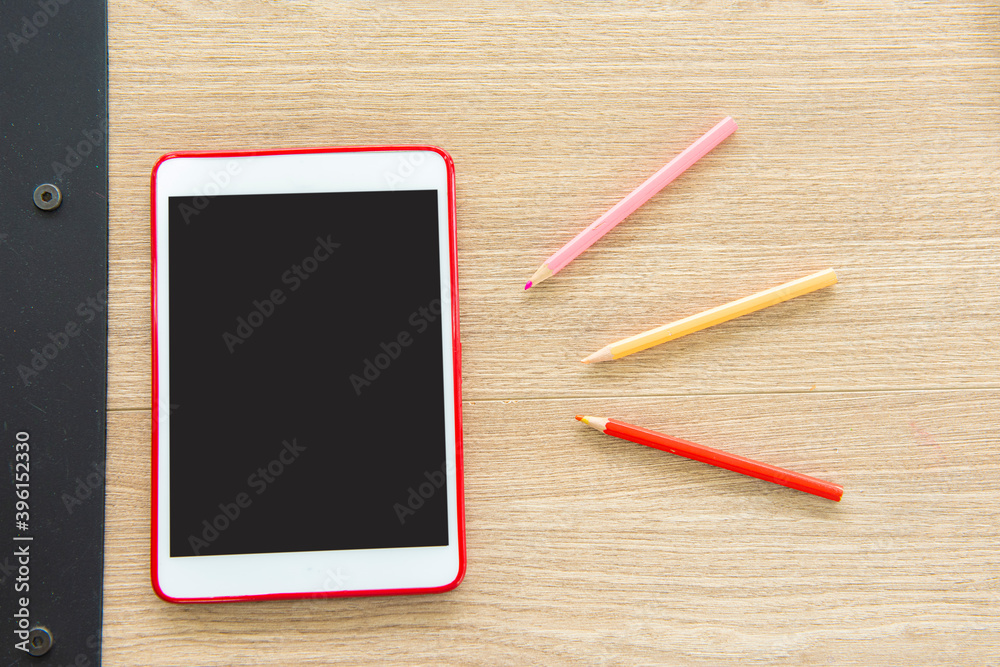 tablet and color pencil on wooden table.flat lay shoot. tablet and color pencil on wooden table.flat lay shoot.