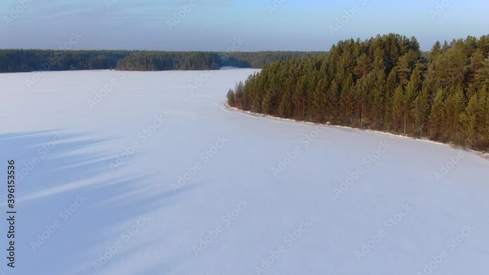Flight over a taiga forest lake in winter Flight over a taiga forest lake in winter