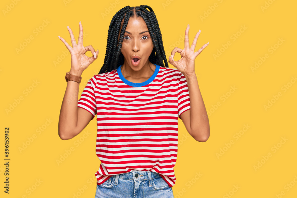 Beautiful hispanic woman wearing casual clothes looking surprised and shocked doing ok approval symbol with fingers. crazy expression Beautiful hispanic woman wearing casual clothes looking surprised and shocked doing ok approval symbol with fingers. crazy expression