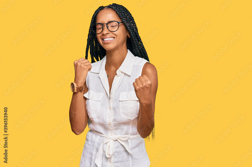 Beautiful hispanic woman wearing casual clothes and glasses very happy and excited doing winner gesture with arms raised, smiling and screaming for success. celebration concept. Beautiful hispanic woman wearing casual clothes and glasses very happy and excited doing winner gesture with arms raised, smiling and screaming for success. celebration concept.