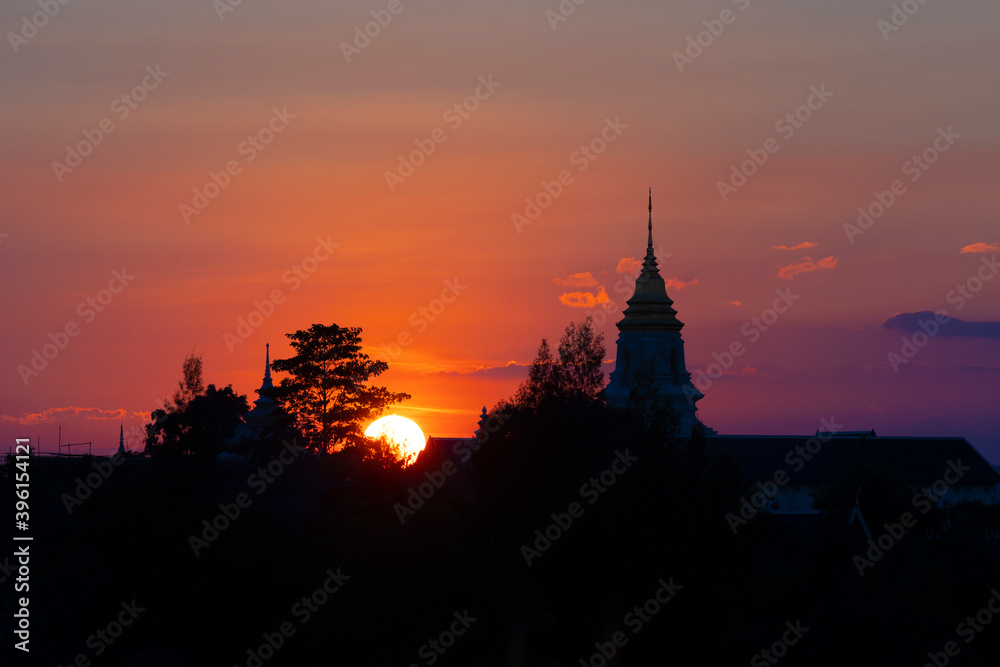 Obraz premium View over the temples of Chaiyaphum in Thailand to the surrounding mountains at sunset