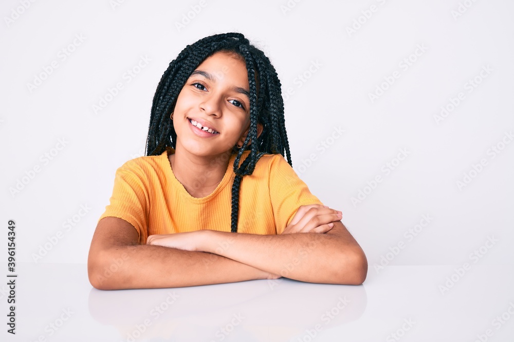 Young african american girl child with braids wearing casual yellow tshirt happy face smiling with crossed arms looking at the camera. positive person. Young african american girl child with braids wearing casual yellow tshirt happy face smiling with crossed arms looking at the camera. positive person.