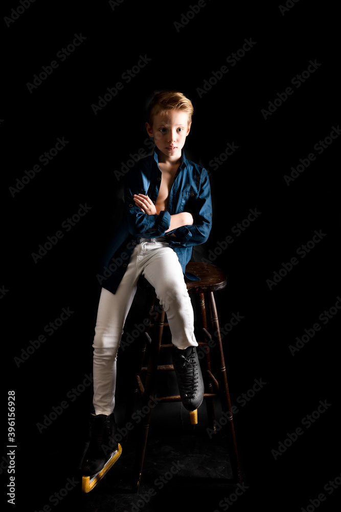 Fototapeta premium Young figure skater dressed in white jeans and blue shirt