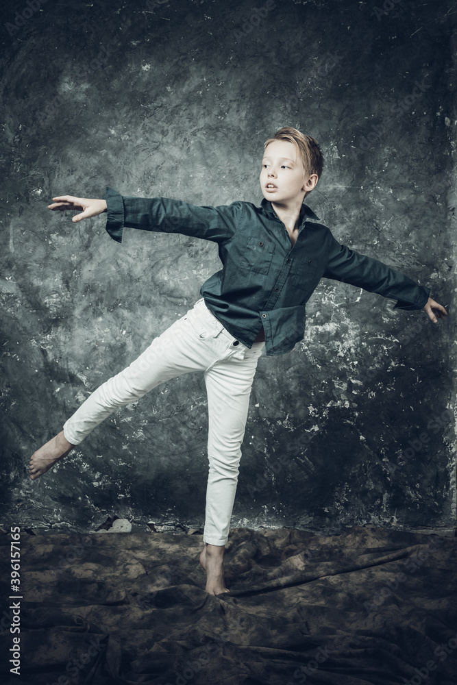 Young dancer dressed in white jeans and blue shirt doing figures studio portrait