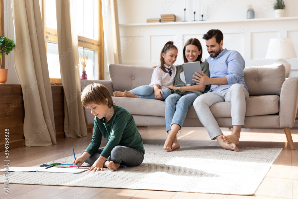 Happy young Caucasian family relax in new cozy design house on weekend, use modern table, little boy son drawing. Overjoyed parents rest in own home enjoy time together with small kids children. Happy young Caucasian family relax in new cozy design house on weekend, use modern table, little boy son drawing. Overjoyed parents rest in own home enjoy time together with small kids children.