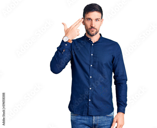 Photography Young handsome man wearing casual shirt shooting and killing oneself pointing hand and fingers to head like gun, suicide gesture