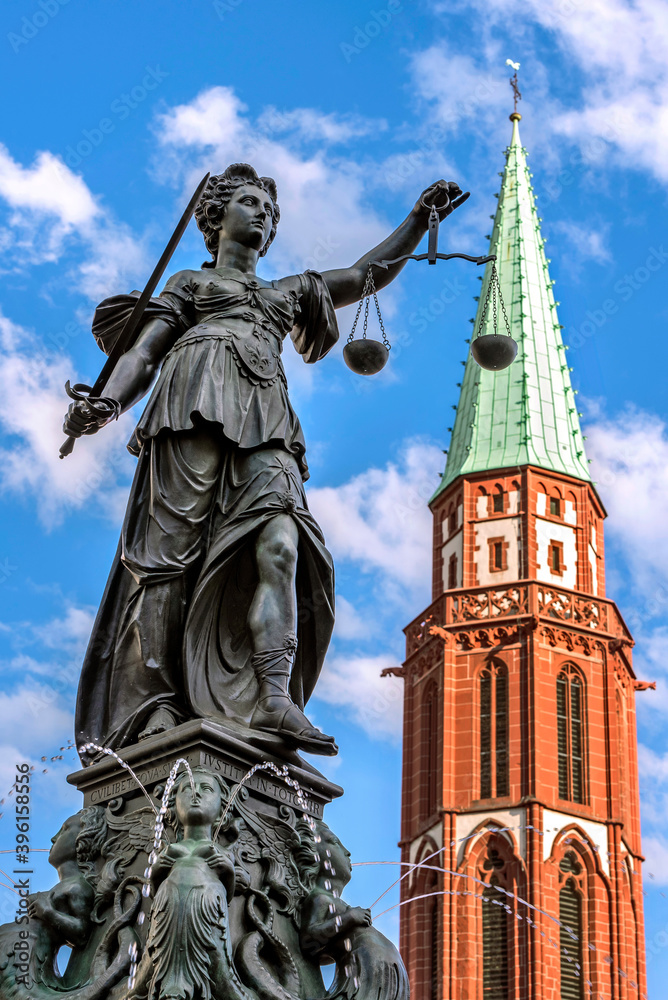 Gerechtigkeitsbrunnen auf dem Frankfurter Römerberg mit der Kirchturmspitze der Alten Nikolaikirche im Hintergrund