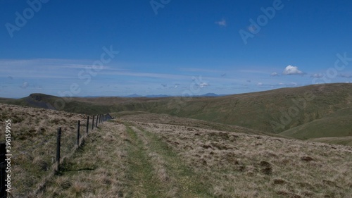 fence between pastures on top of Scottish hills on a hot summer day