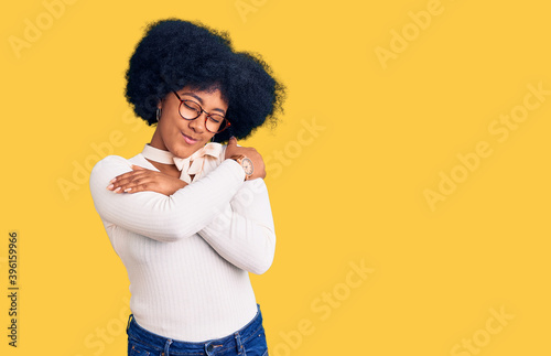 Young african american girl wearing casual clothes and glasses hugging oneself happy and positive, smiling confident. self love and self care