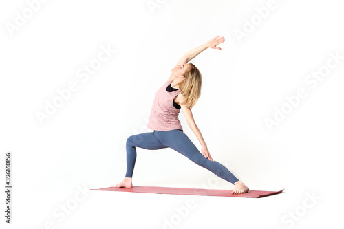 middle aged woman yoga asanas. instructor shows a pose from yoga isolated on a white background. woman practicing yoga concept natural balance between body and mental development.