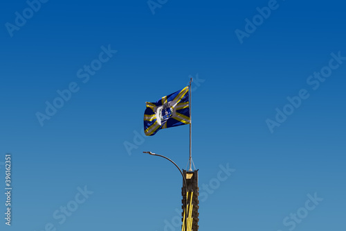 Bandeira da cidade de Anápolis balançando ao vento com o céu azul ao fundo. Foto feita na cidade de Anápolis em Goiás, Brasil.