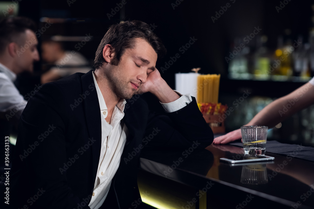 a tired man fell asleep at the bar in a restaurant. a tired man fell asleep at the bar in a restaurant.