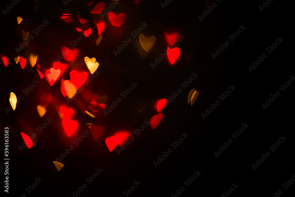 Abstract bokeh hearts background wallpaper. lights in the night city. Red and golden lights bokeh. Glowing shiny romantic background for Christmas, New Year, Valentine's Day.