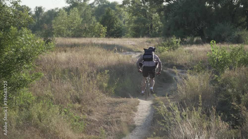 Man exploring single track trail on mountain bike. Male athlete mountainbiker rides bicycle along country road in summer. Sport and healthy life. Cyclist on country road. Biking on cross country road Man exploring single track trail on mountain bike. Male athlete mountainbiker rides bicycle along country road in summer. Sport and healthy life. Cyclist on country road. Biking on cross country road