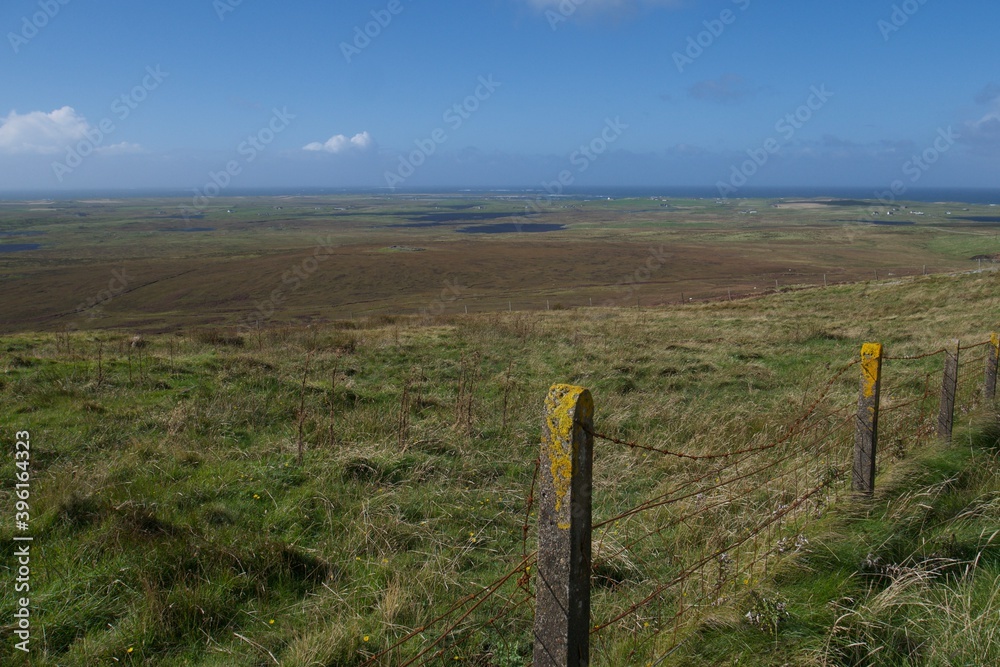 View of a typical Scottish landscape with a lot of lochs and peat land from a hill on North Uist on a nice bright day