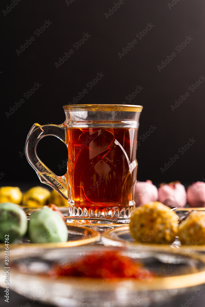 Tea with saffron, dates with chocolate on black background Tea with saffron, dates with chocolate on black background