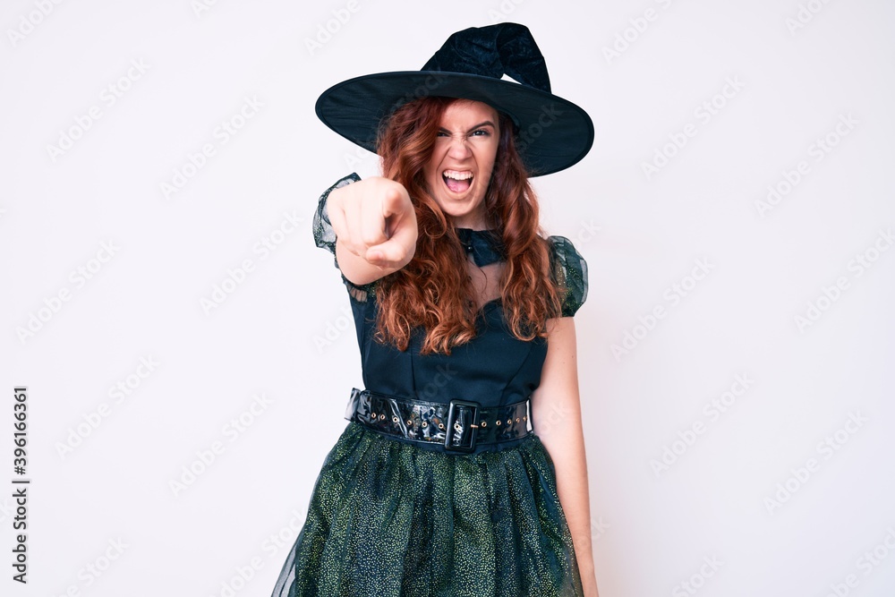 Young beautiful woman wearing witch halloween costume pointing displeased and frustrated to the camera, angry and furious with you Young beautiful woman wearing witch halloween costume pointing displeased and frustrated to the camera, angry and furious with you