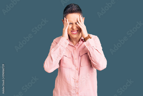 Young woman with short hair wearing casual clothes with hand on head, headache because stress. suffering migraine.