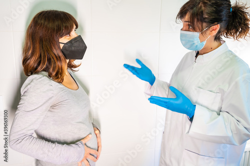 Female doctor and patient with face mask in a routine consultation. Antibodies, immunize population. side effects, risk people, antibodies, new normal, covid-19.