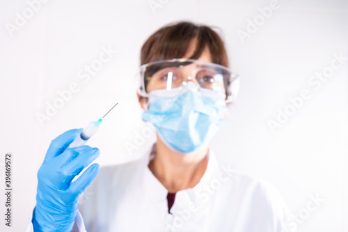 Female doctor with transparent glasses face mask with coronavirus vaccine, antibodies, immunize population. side effects, risk people, antibodies, new normal, covid-19.
