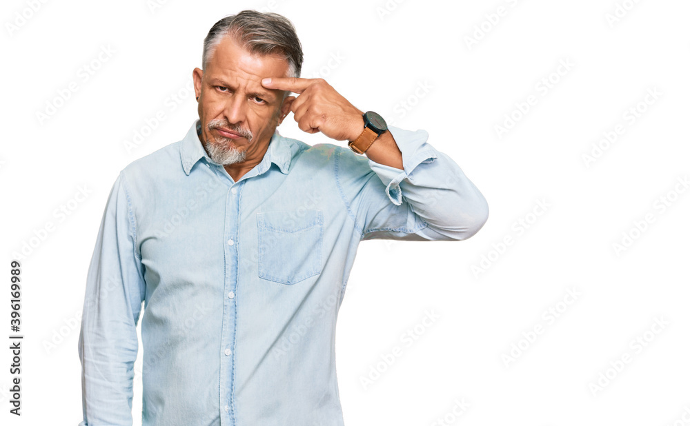 Middle age grey-haired man wearing casual clothes pointing unhappy to pimple on forehead, ugly infection of blackhead. acne and skin problem Middle age grey-haired man wearing casual clothes pointing unhappy to pimple on forehead, ugly infection of blackhead. acne and skin problem