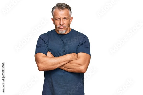 Middle age grey-haired man wearing casual clothes skeptic and nervous, disapproving expression on face with crossed arms. negative person.