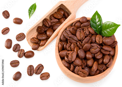 roasted coffee beans with green leaves and wooden spoon in wooden bowl isolated on white background. Clipping path and full depth of field. Top view
