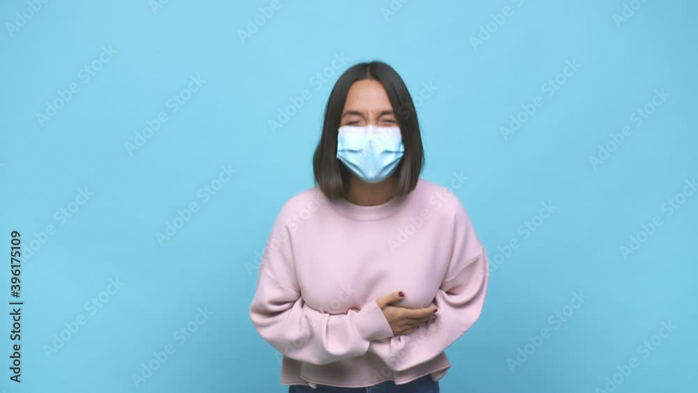 Young hispanic woman wearing antiviral mask showing thumb down and expressing dislike Young hispanic woman wearing antiviral mask showing thumb down and expressing dislike