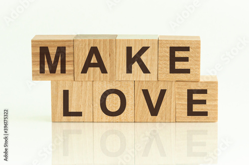 Fototapeta Naklejka Na Ścianę i Meble -  Make Love - text on wooden cubes on a white gradient background