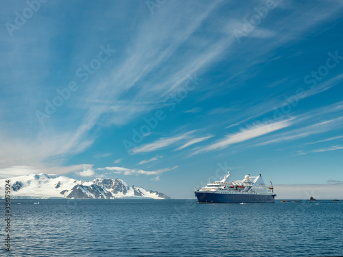 Fototapeta Naklejka Na Ścianę i Meble -  view to passenger vessel in Antarctic waters under blue sky with light clouds and copy space