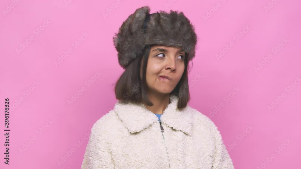 Young hispanic woman wearing a winter hat face closeup feels proud and self confident, example to follow Young hispanic woman wearing a winter hat face closeup feels proud and self confident, example to follow