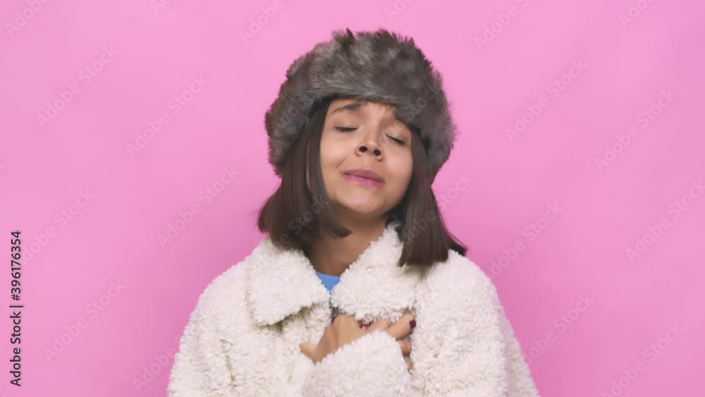 Young hispanic woman wearing a winter hat face closeup hugs, smiling carefree and happy Young hispanic woman wearing a winter hat face closeup hugs, smiling carefree and happy