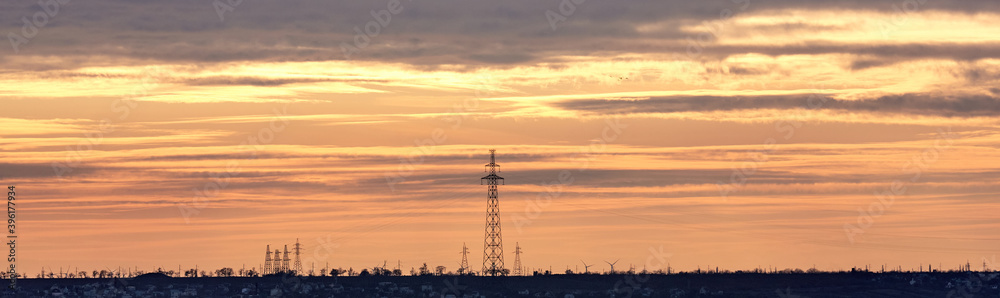 Power lines against the background of a yellow-orange multicolor sunset