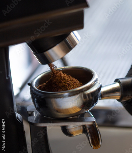 coffee grinder grinding coffee pouring into a portafilter