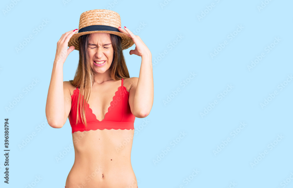 Beautiful brunette young woman wearing bikini with hand on head for pain in head because stress. suffering migraine. Beautiful brunette young woman wearing bikini with hand on head for pain in head because stress. suffering migraine.