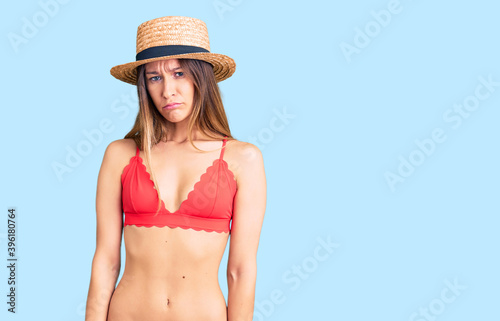 Beautiful brunette young woman wearing bikini skeptic and nervous, frowning upset because of problem. negative person.