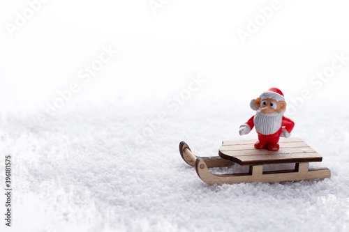 Santa Claus in a sleigh on a white background in the snow under clipping. Horizontal orientation. Copy space. Empty space. The concept of a new year. Christmas toy on a sled in a snowdrift