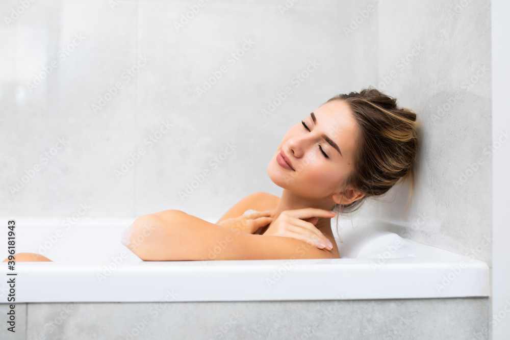 Young beautiful woman relaxing in bathtub at home Young beautiful woman relaxing in bathtub at home
