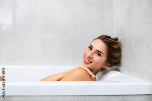 Portrait of young woman relaxing in bathtub at home