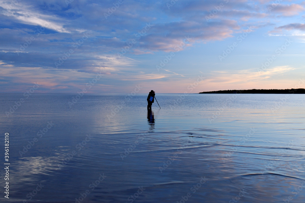 Photographer standing in the lake at dusk
