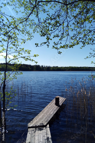 Fototapeta Naklejka Na Ścianę i Meble -  lake with a wooden pier on a sunny clear day.