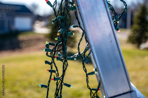 Selective focus on Christmas lights hanging off a ladder rung