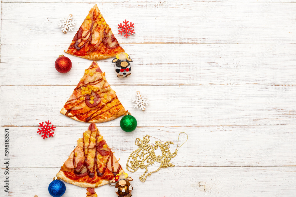 Christmas tree made of pizza on a white wooden background.