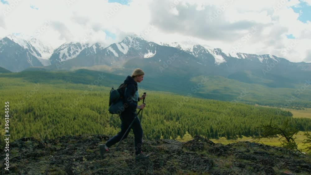 Female traveler who reached а mountain top and waving to friends below. Joy of victory and outdoor activities in the mountains in summer, 4K, HD Female traveler who reached а mountain top and waving to friends below. Joy of victory and outdoor activities in the mountains in summer, 4K, HD