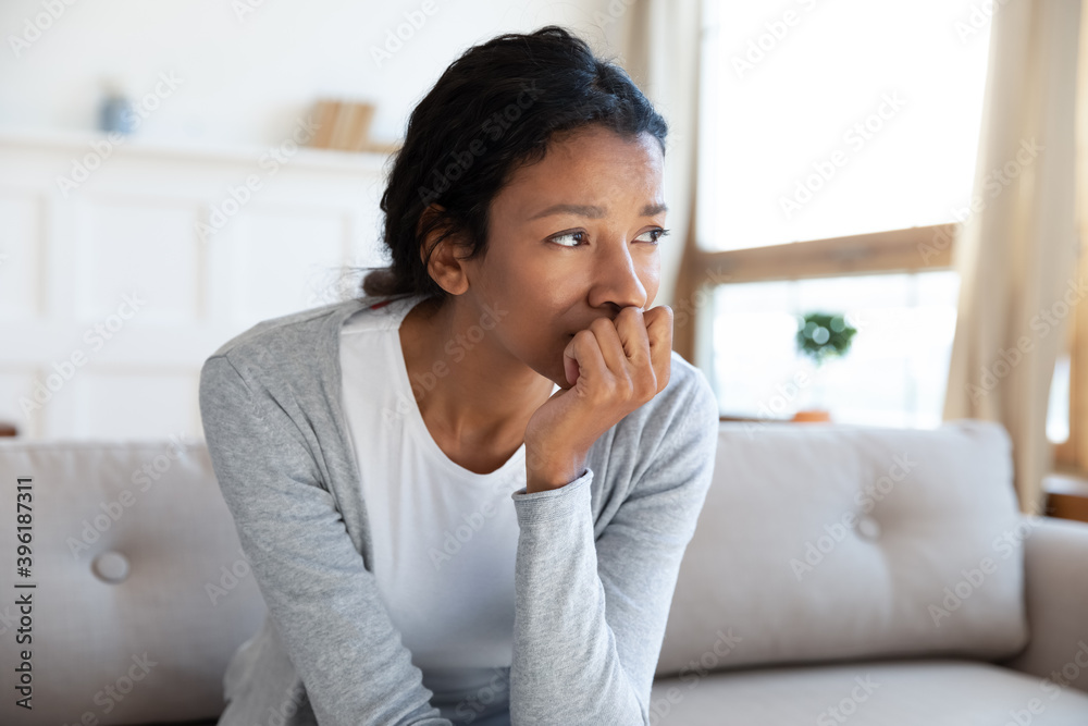 Upset young African American woman look in distance crying mourning, feeling lonely at home. Unhappy sad millennial biracial female lost in thoughts, suffer from personal problems. Depression concept. Upset young African American woman look in distance crying mourning, feeling lonely at home. Unhappy sad millennial biracial female lost in thoughts, suffer from personal problems. Depression concept.