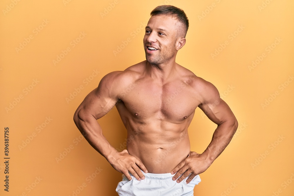 Handsome bodybuldier man posing sexy showing muscle, shirtless torso showing pectorals and sixpack