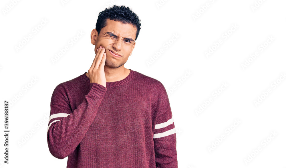 Hispanic handsome young man wearing casual clothes touching mouth with hand with painful expression because of toothache or dental illness on teeth. dentist Hispanic handsome young man wearing casual clothes touching mouth with hand with painful expression because of toothache or dental illness on teeth. dentist