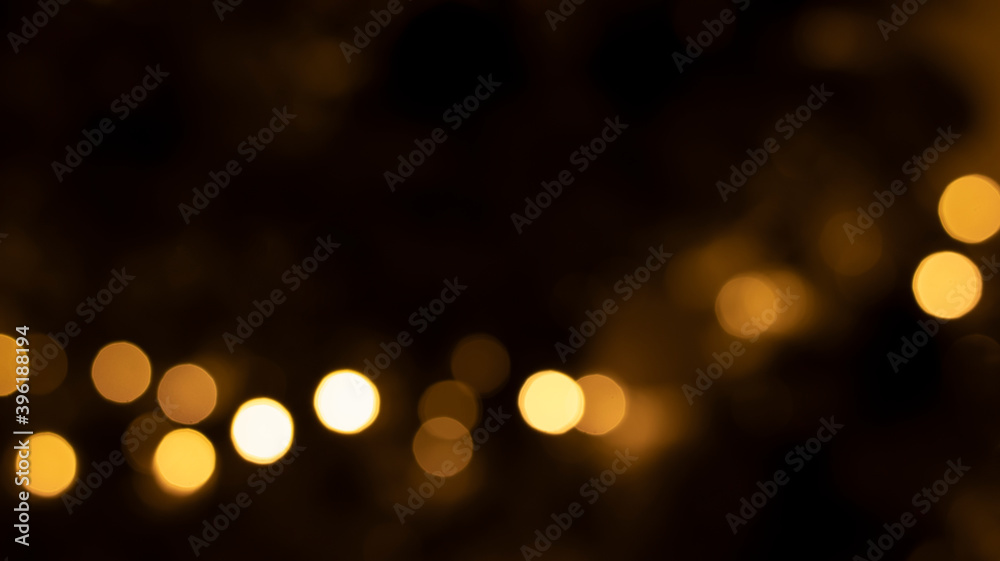 Blurred golden bokeh background on black. Festive light effect. Blurred golden bokeh background on black. Festive light effect.