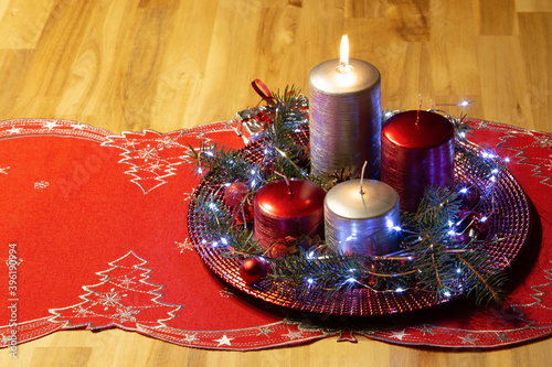 Advent wreath with one burning candle.
